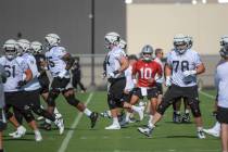 Las Vegas Raiders quarterback Jimmy Garoppolo (10) warms up with teammates during practice at t ...