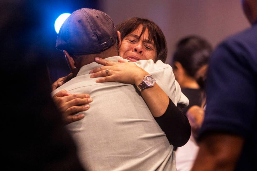 Attendees embrace during a church service at King's Cathedral in Kahului on the island of Maui, ...