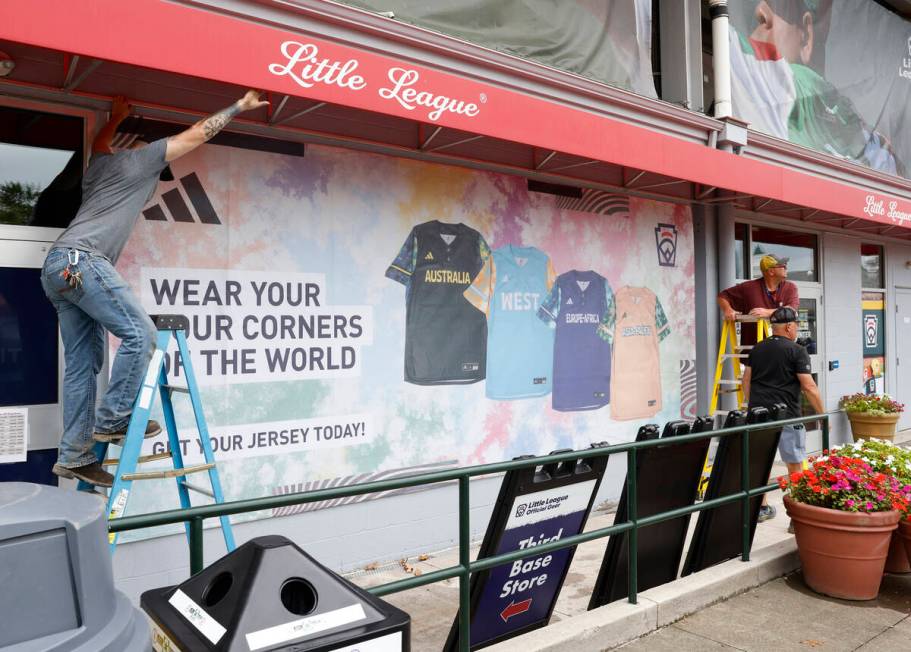 Workers display banners for the Little League World Series at Howard J. Lamade Stadium, on Tues ...