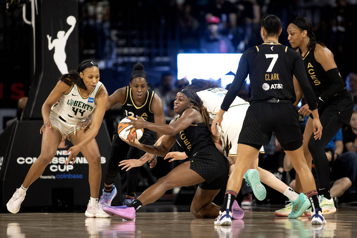 Las Vegas Aces guard Jackie Young (0) struggles for the ball while New York Liberty forward Bet ...