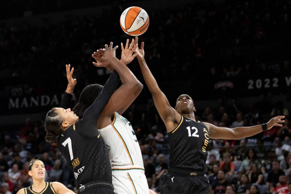 New York Liberty forward Jonquel Jones, center, shoots against Las Vegas Aces forward Alysha Cl ...