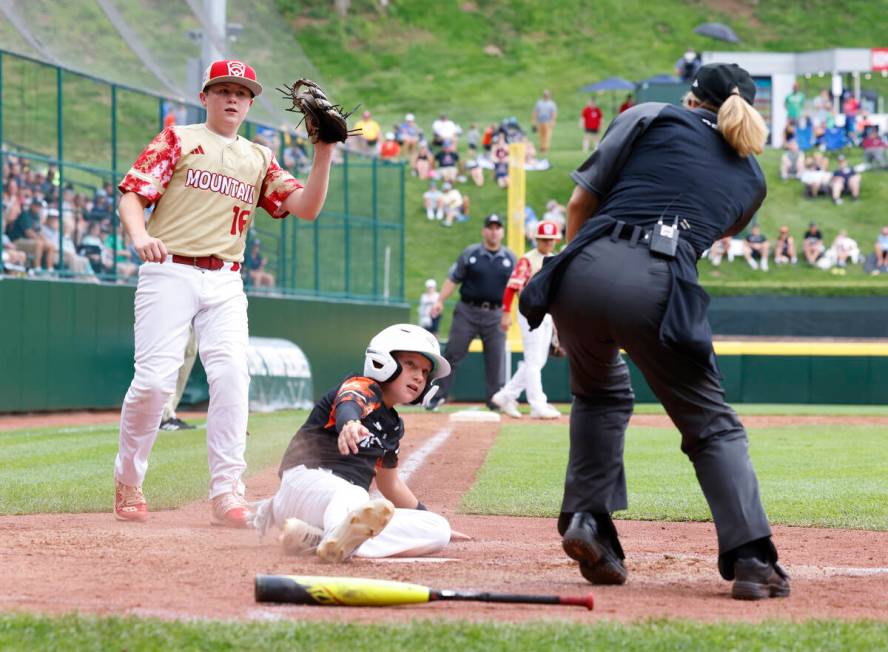 Rhode Island's John Wozniak is tagged out at home by the Henderson All-Stars pitcher Logan Leva ...