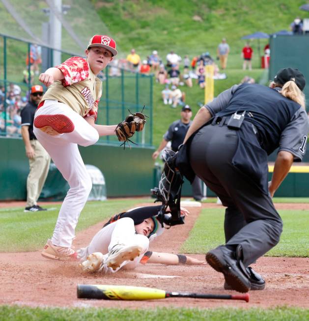 Rhode Island's John Wozniak is tagged out at home by the Henderson All-Stars pitcher Logan Leva ...