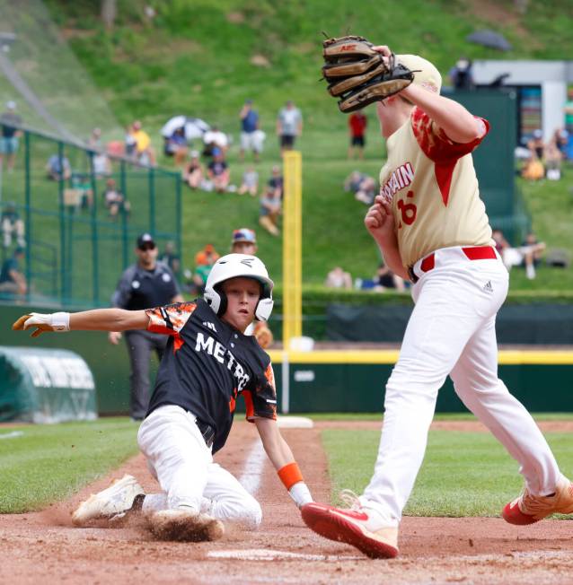 Rhode Island's Brady McShane (3) beats a throw and scores before Henderson All-Stars pitcher Lo ...