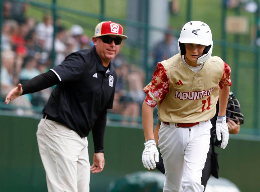 The Henderson All-Stars centerfielder Jaxson McMullen runs past assistant coach Arlie Daniel af ...