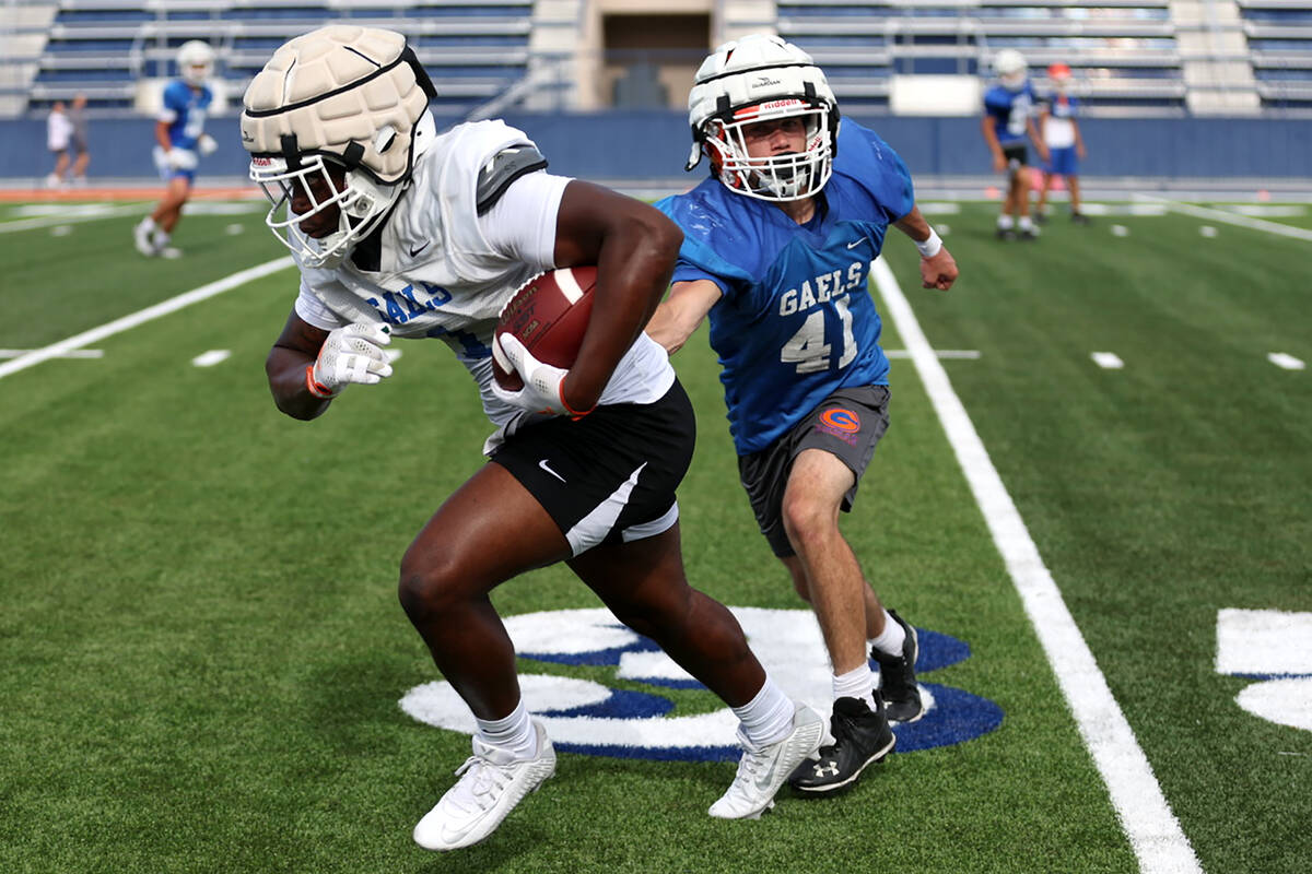 Bishop Gorman's Elija Lofton, left, runs the ball during football practice at Bishop Gorman Hig ...