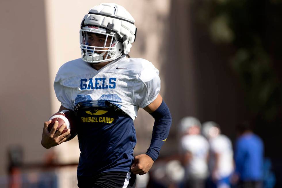 Bishop Gorman running back Micah Kaapana runs the ball during football practice at Bishop Gorma ...