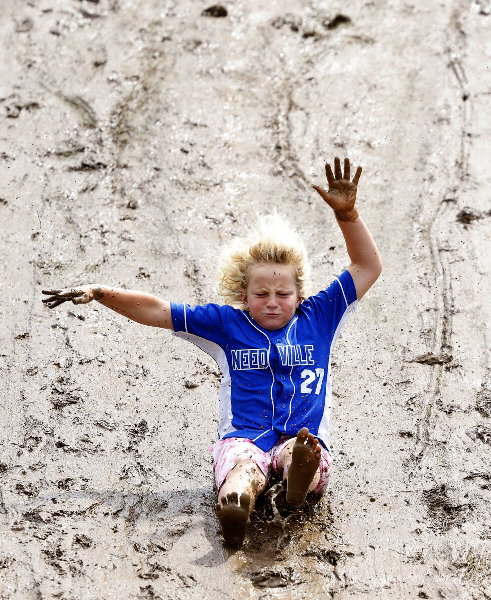 Weston Hammonds, 10, of Linnville, Texas, slides on the muddy hillside overlooking Howard J. La ...