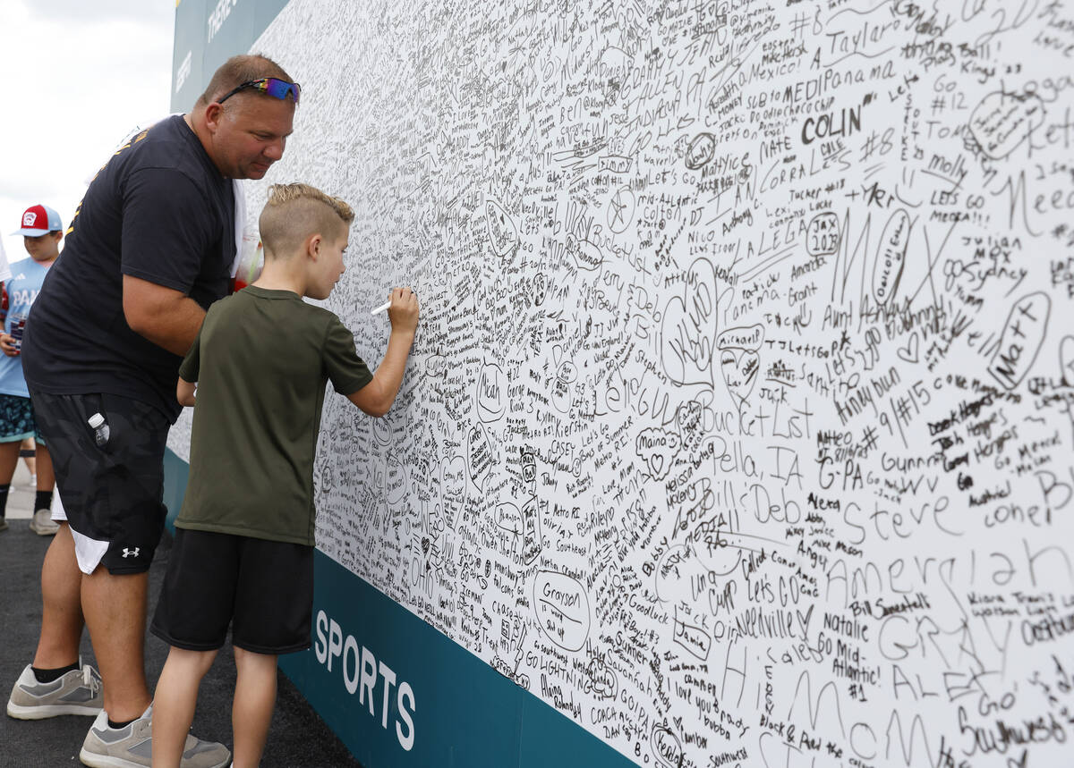 Fans write messages on a wall outside of Howard J. Lamade Stadium where the Little League World ...