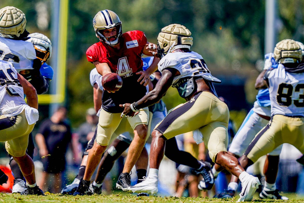 New Orleans Saints quarterback Derek Carr (4) hands off the ball to running back Jamaal William ...