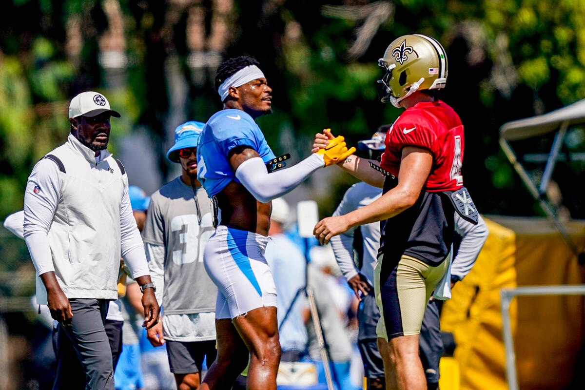 Los Angeles Chargers safety Derwin James Jr., center left, greets New Orleans Saints quarterbac ...