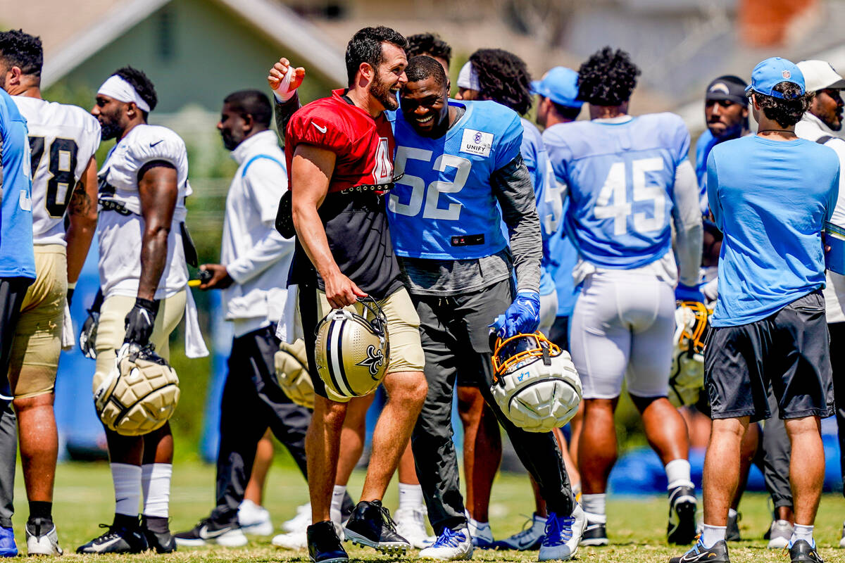 Los Angeles Chargers linebacker Khalil Mack (52) hugs New Orleans Saints quarterback Derek Carr ...