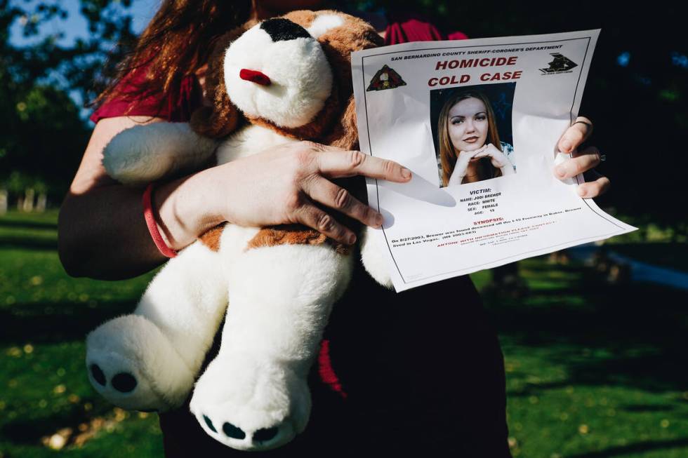 Nathalie Walker holds a flyer about Jodi Brewer’s unsolved killing and a stuffed dog tha ...