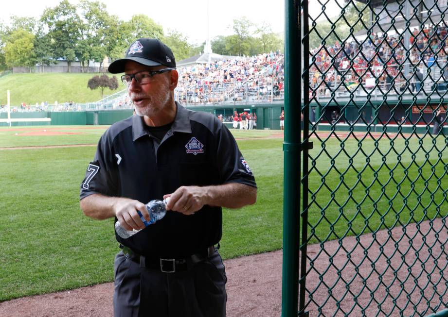 Ben Sprague of Las Vegas, right, a volunteer umpire, takes a break between innings during the L ...