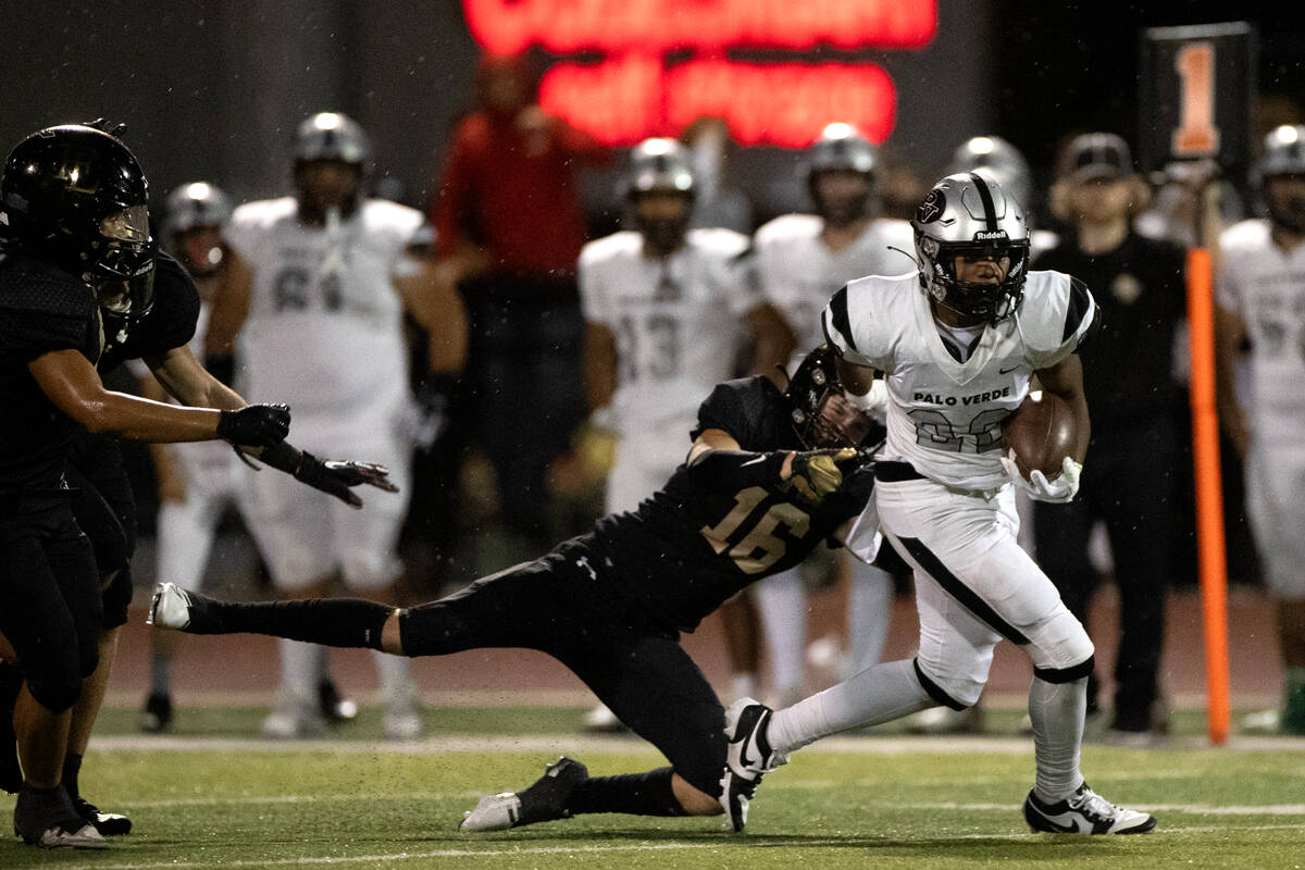Palo Verde’s Bryant Johnson (20) evades a tackle from Faith Lutheran’s 6 Matthew ...