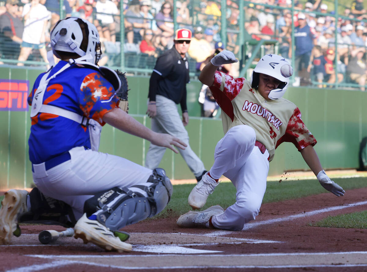 The Henderson All-Stars pitcher David Edwards (15) avoids the tag from New Albany, Ohio, catche ...