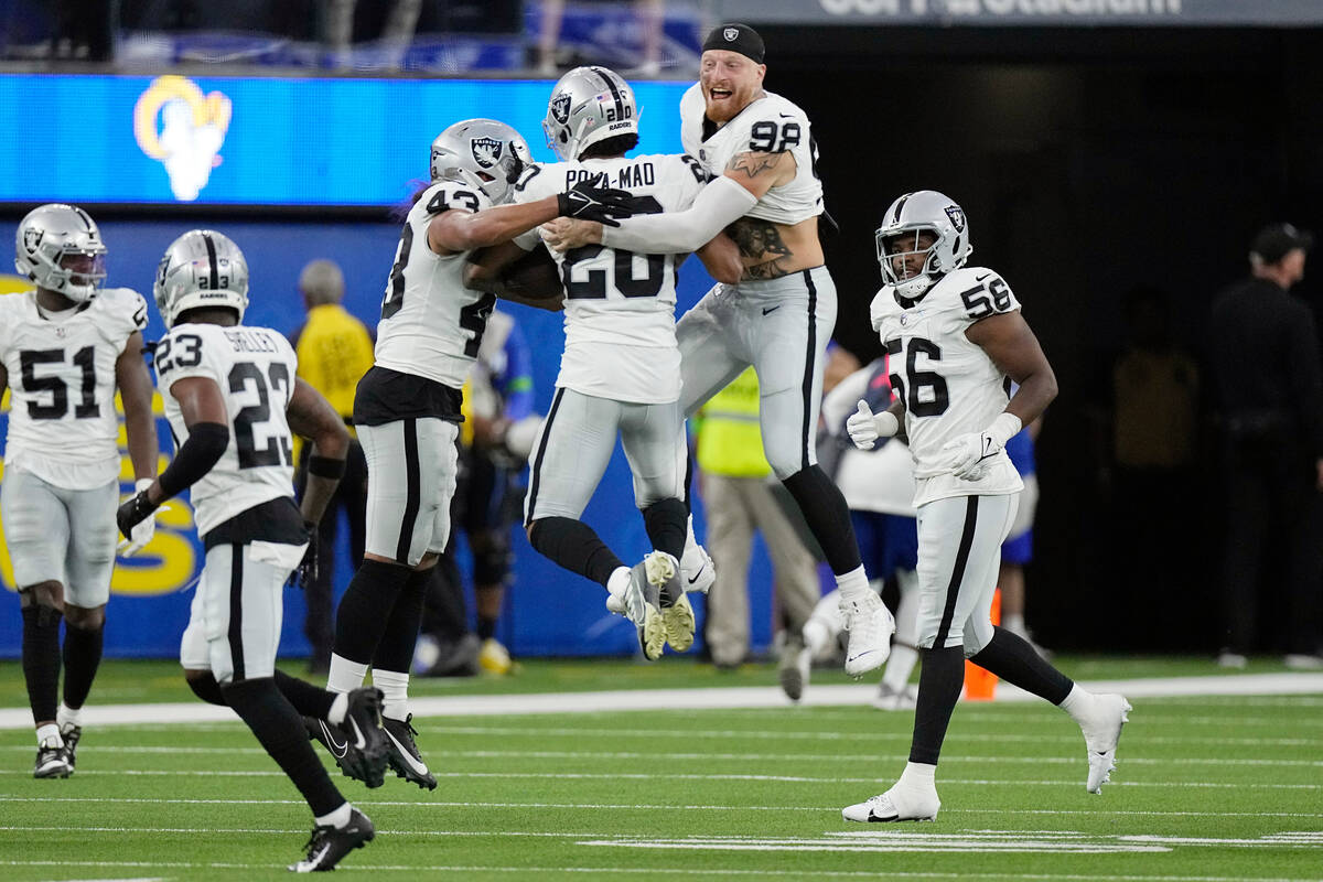 Las Vegas Raiders safety Isaiah Pola-Mao, center, celebrates with defensive end Maxx Crosby (98 ...