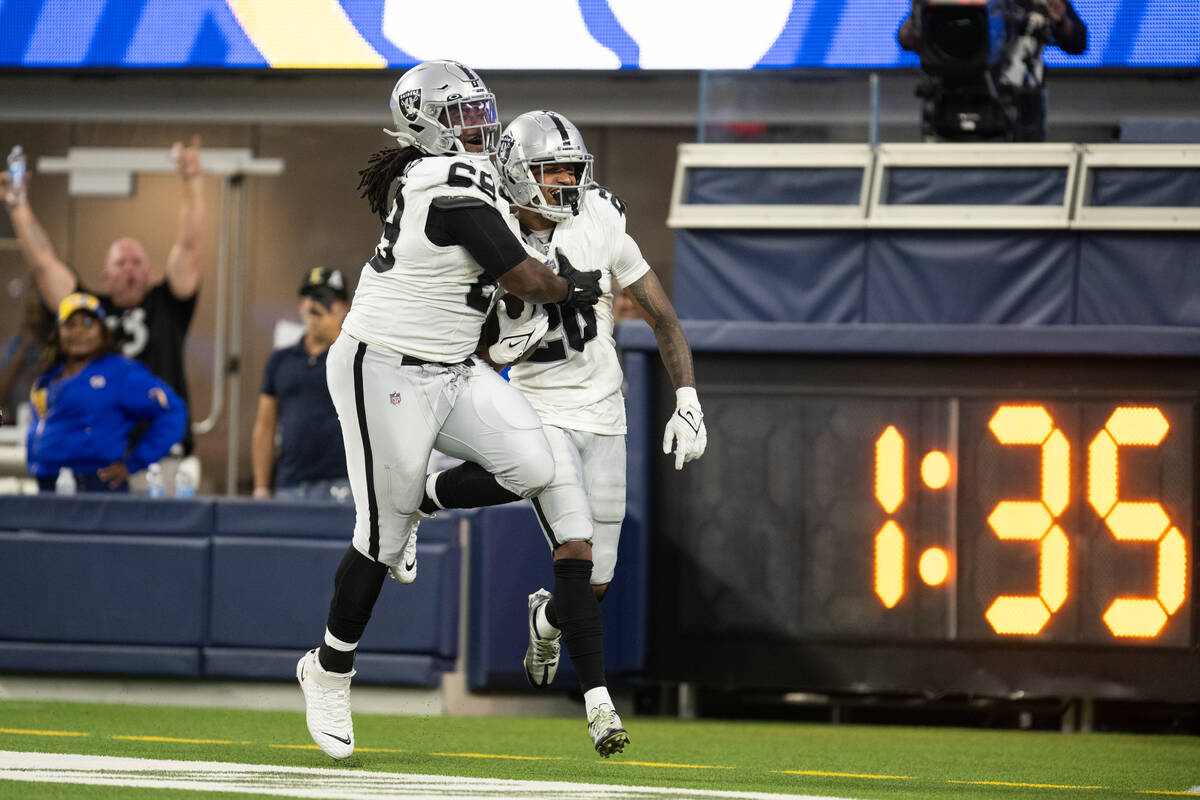 Las Vegas Raiders safety Isaiah Pola-Mao (20) and center Andre James (68) celebrate Pola-Mao's ...