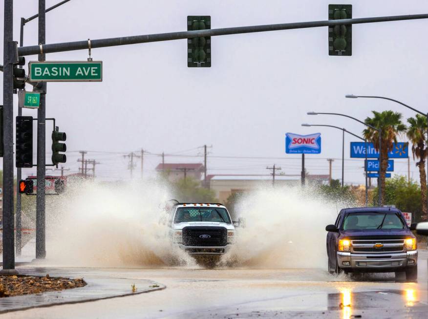 A truck throws up lots of standing water in the intersection along South Highway 160 at Basin A ...