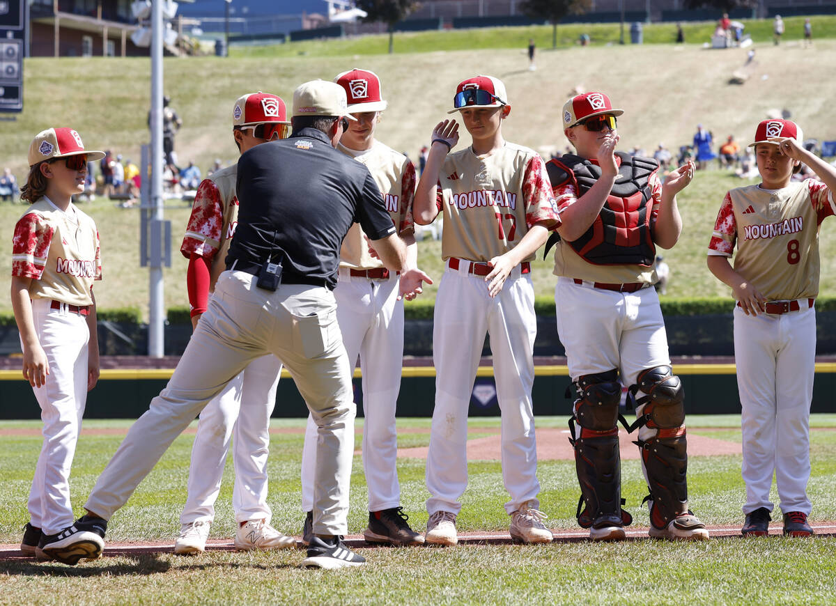 The Henderson All-Stars manager Ryan Gifford is greeted by his players as the team takes the fi ...