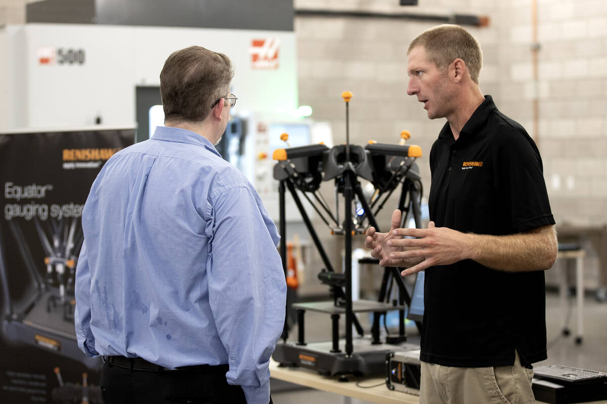 Devon King, Renishaw regional manager, right, explains one of the machines that will be used at ...
