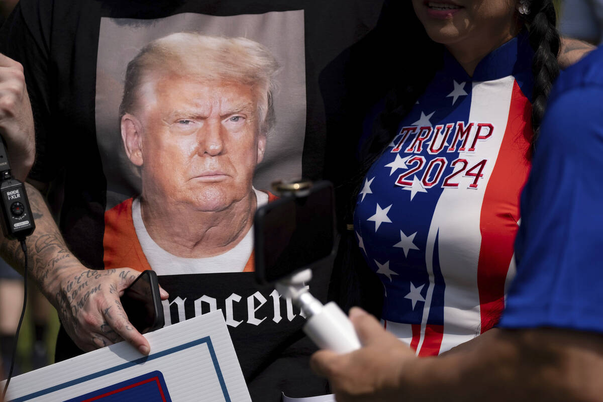 Supporters of former President Donald Trump and journalists gather in front of the Fulton Count ...