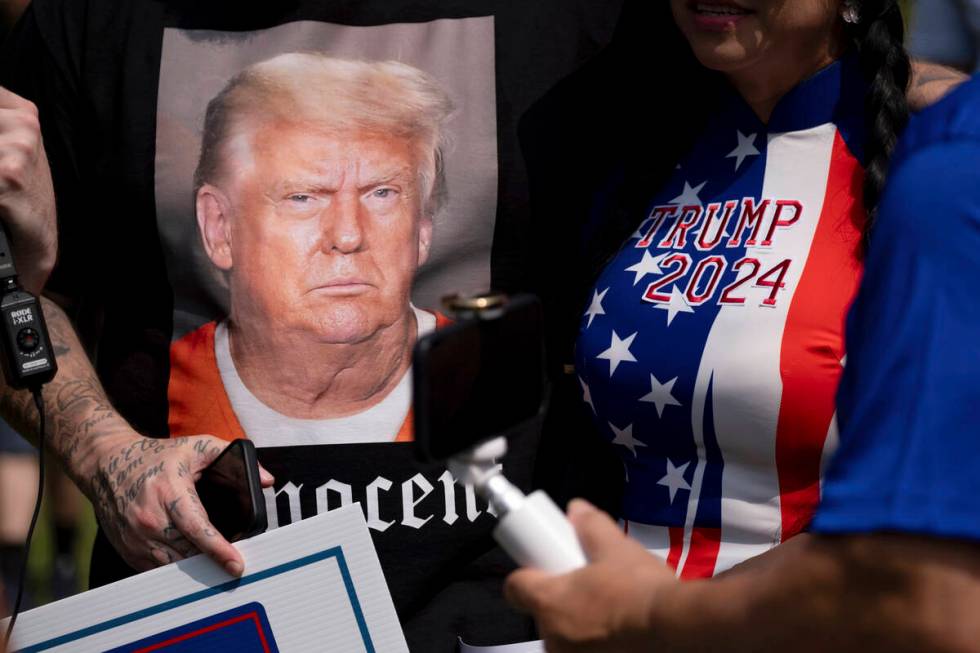 Supporters of former President Donald Trump and journalists gather in front of the Fulton Count ...