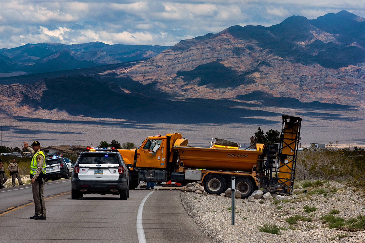 A rock truck is soon to be towed after spilling its load along Kyle Canyon Road below Mount Cha ...