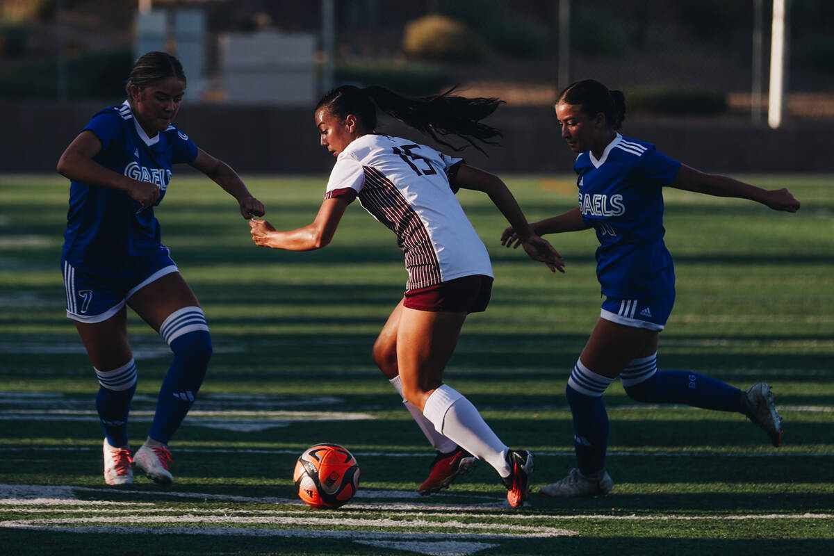 Bishop Gorman midfielder Gwen Flemington (15) tries to keep the ball in her possession during a ...