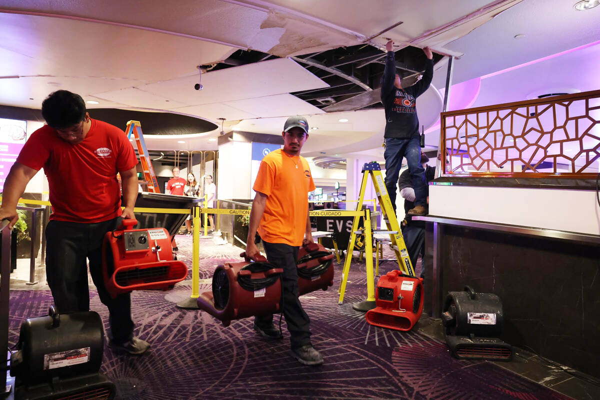 Workers repair tiles damaged in a storm overnight at Harrah’s on Aug. 24, 2023, in Las Vegas. ...