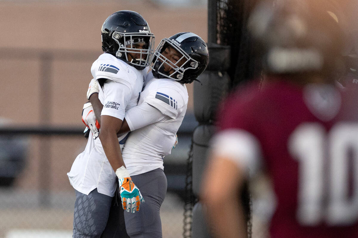 Desert Pines wide receiver Trey Jackson, left, is congratulated by a teammate even though his t ...