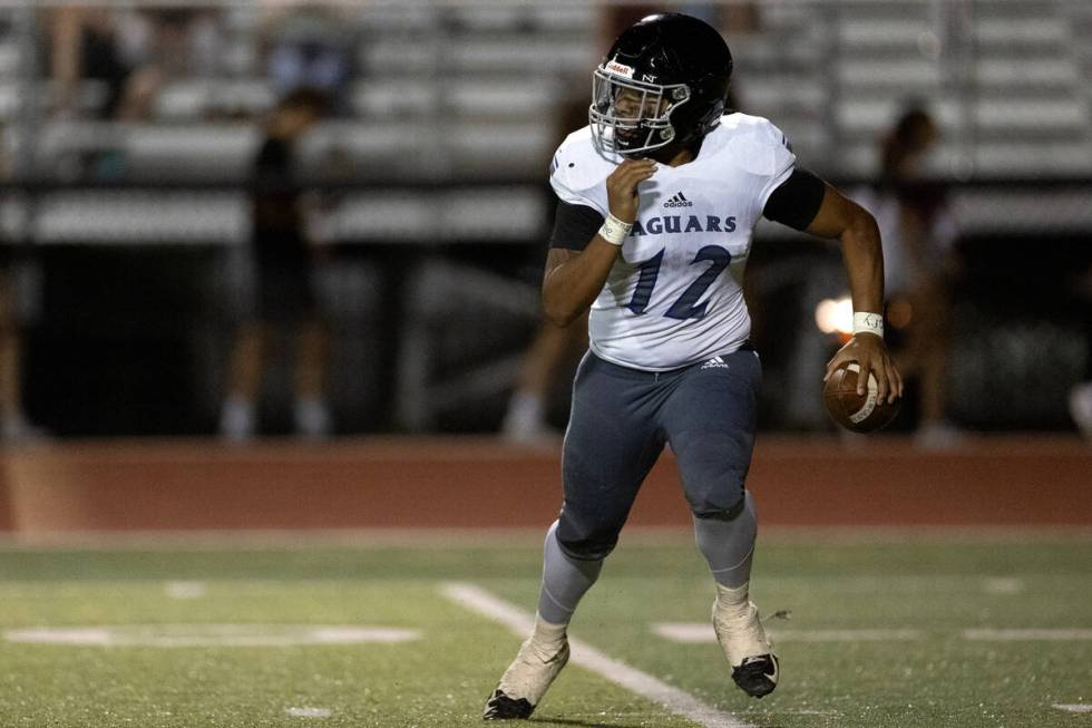 Desert Pines quarterback AJ Stowers (12) decides to run the ball during the second half of a hi ...