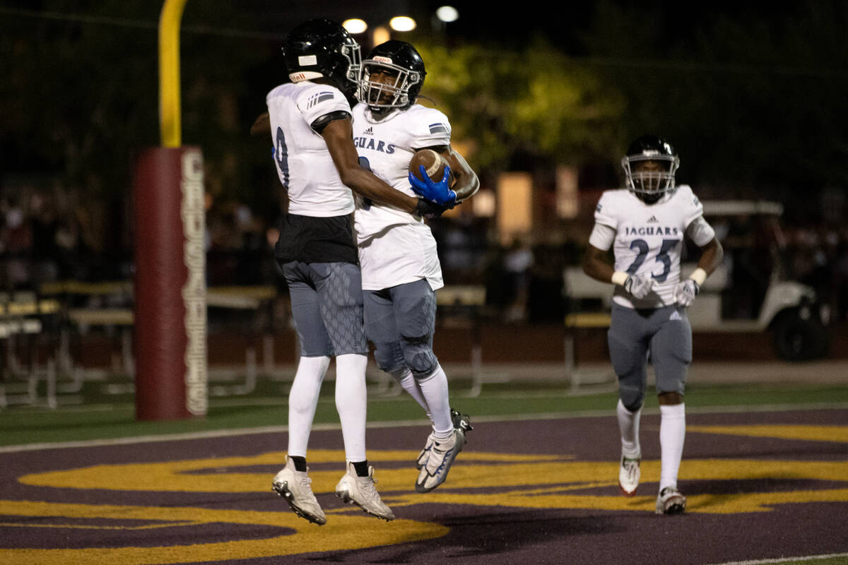 Desert Pines wide receiver Niqel Junor, center, jumps to celebrate his touchdown with wide rece ...