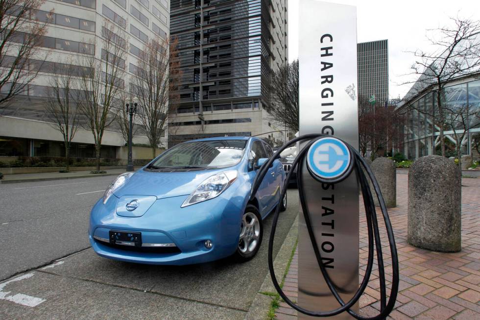 A car is parked by an electric charging station in downtown Portland, Ore., March 31, 2011. (AP ...