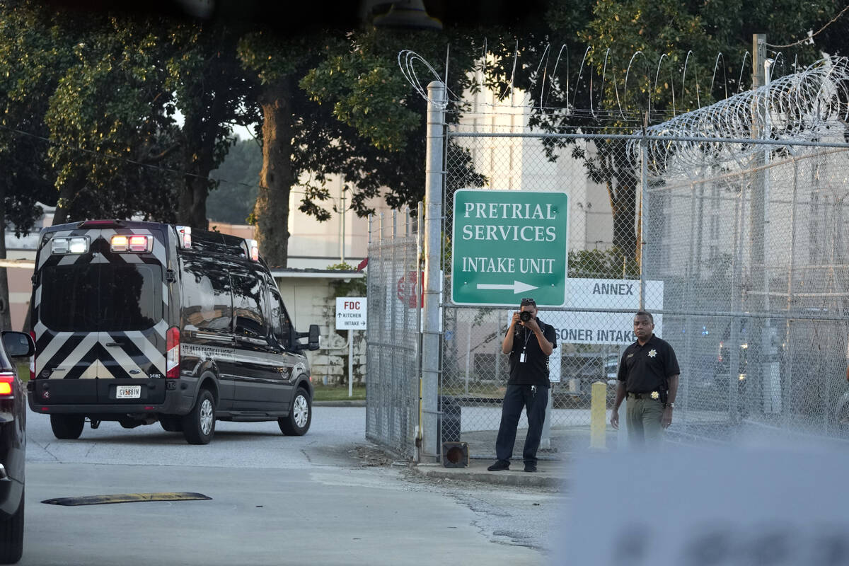 The motorcade of former President Donald Trump arrives at the Fulton County Jail, Thursday, Aug ...