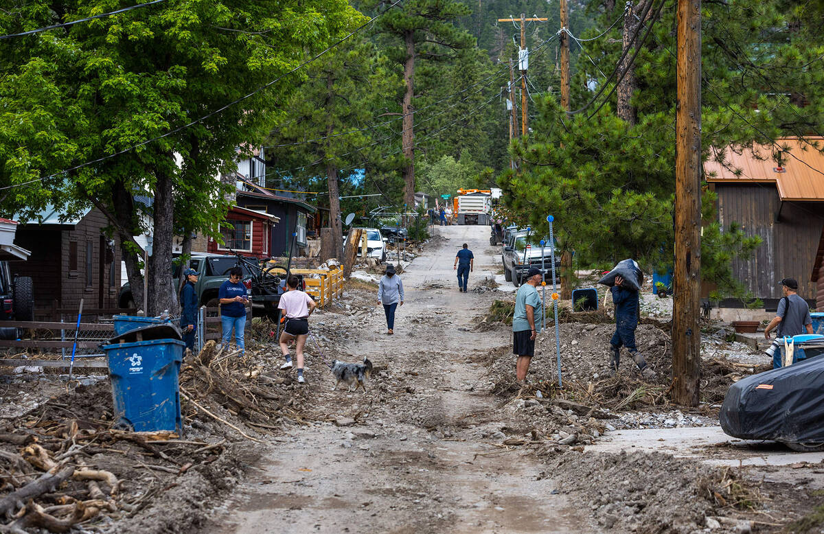 Residents gather along Yellow Pine Ave. in Old Town as cleanup from the extensive damage of tro ...