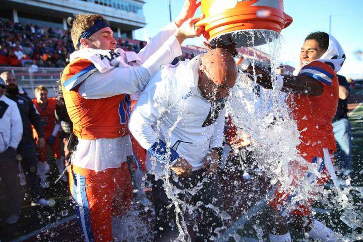 Bishop Gorman's head football coach Kenny Sanchez, center, gets a Gatorade (water) shower by hi ...