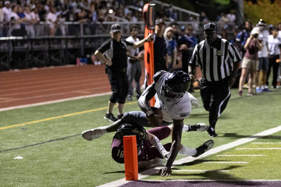 Desert Pines running back Greg Burrell (5) reaches his hand into the end zone to score a touchd ...