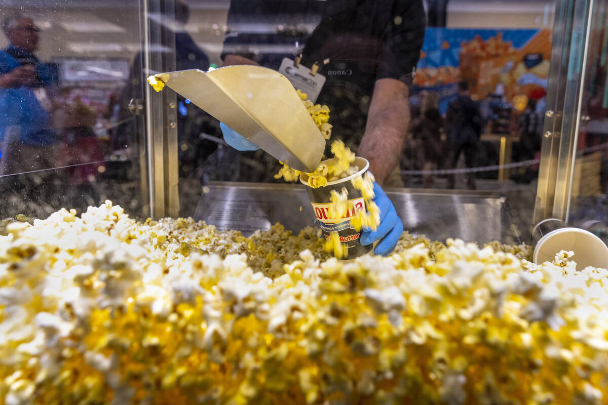 Another sample of LouAna real buttered popcorn is scooped up during CinemaCon at Caesars Palace ...