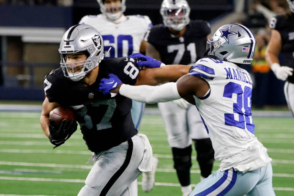 Las Vegas Raiders tight end Michael Mayer (87) fights off a tackle by Dallas Cowboys cornerback ...