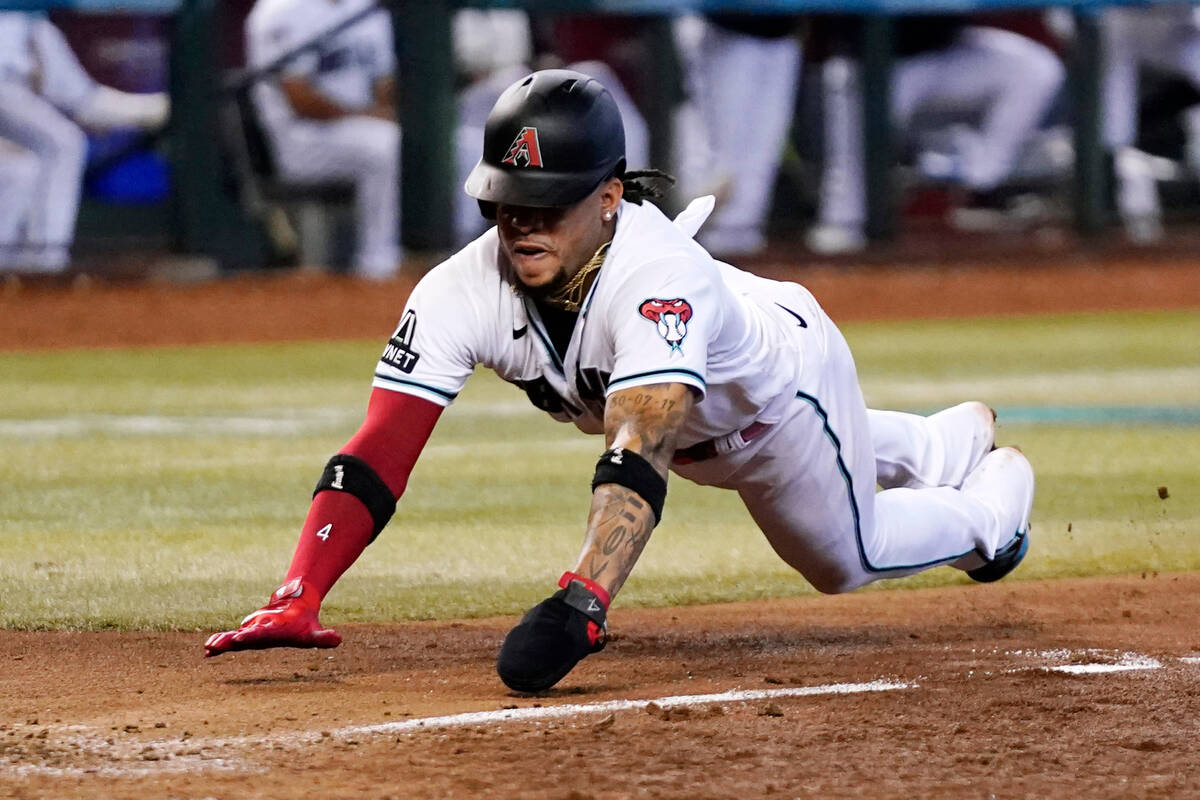 Arizona Diamondbacks' Ketel Marte dives to score a run against the Cincinnati Reds during the e ...