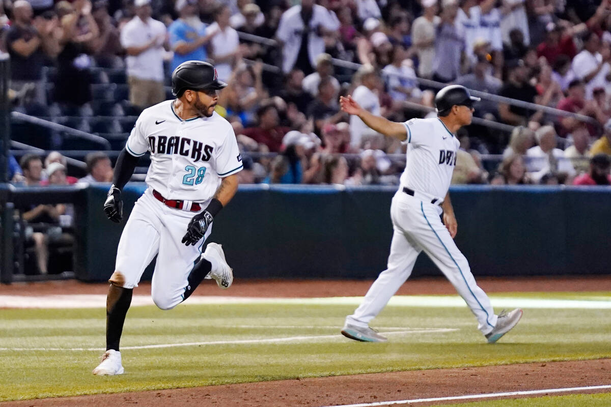 Arizona Diamondbacks' Tommy Pham (28) is waved home by Diamondbacks third base coach Tony Perez ...