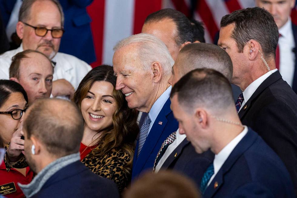 President Joe Biden takes a photo with an attendee after talking about lowering prescription dr ...