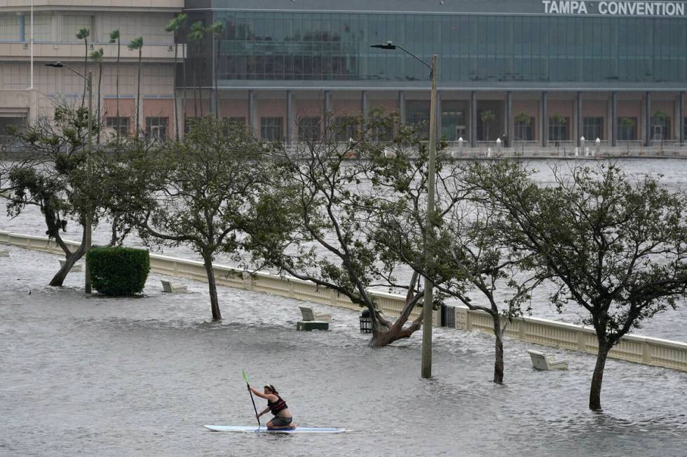 Zeke Pierce rides his paddle board down the middle of a flooded Bayshore Blvd in downtown in Ta ...