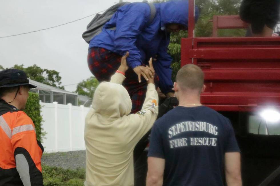 Janecia Wallace, 18, climbs down a ladder with the help of her brother, Julian Wallace, 13, aft ...