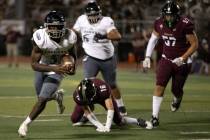 Desert Pines running back Greg Burrell (5) evades tackle from Faith Lutheran fast safety Matthe ...