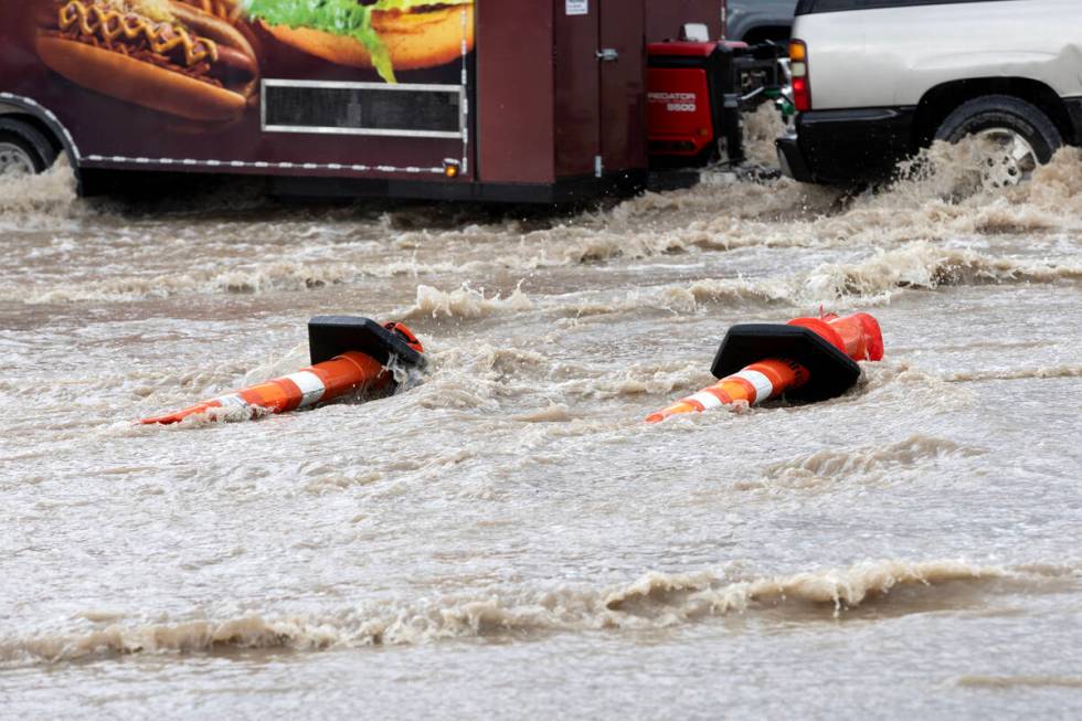 Cones are knocked over while a trailer drives through flash flooding at East Sahara Avenue and ...