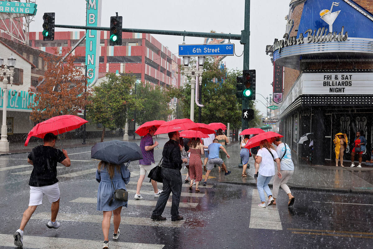 A tour group braves the rain on East Fremont Street in downtown Las Vegas on Friday, Sept. 1, 2 ...