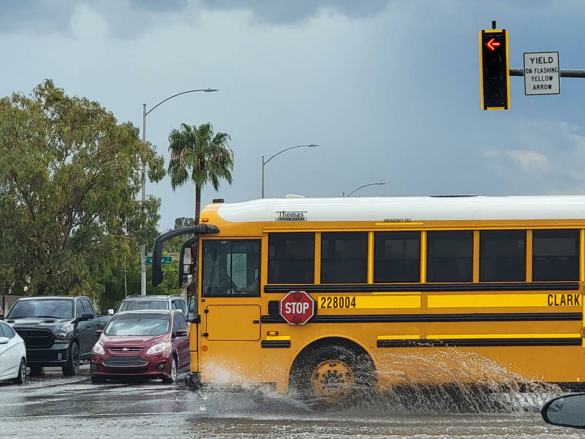 A Clark County School District bus navigates through wet streets at Windmill and Spencer on Fri ...