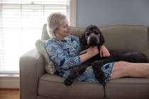 Sally Nix lies on the couch with her service dog, Jon Snow, at home in Statesville, North Carol ...